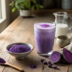 Poudre d’ube violette dans un bol avec une boisson latte en arrière-plan